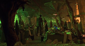 Movie still from “Beetlejuice” (1988), directed by Tim Burton – A group of people standing in a room with green lighting; Wide shot, High angle