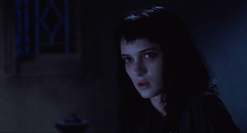 Movie still from “Beetlejuice” (1988), directed by Tim Burton – A young woman with blue eyes is in the dark; Close Up shot, Low angle