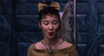 Movie still from “Beetlejuice” (1988), directed by Tim Burton – A woman with a bow in her hair and wearing a necklace; Close Up shot, Low angle