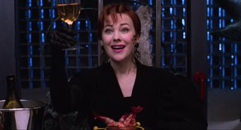 Movie still from “Beetlejuice” (1988), directed by Tim Burton – A woman sitting at a table with a glass of wine; Close Up shot, Low angle