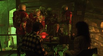 Movie still from “Beetlejuice” (1988), directed by Tim Burton – A group of people sitting at a table in a room; Wide shot, High angle