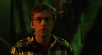 Movie still from “Beetlejuice” (1988), directed by Tim Burton – A young man wearing glasses and a checkered shirt; Close Up shot, Low angle