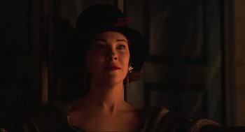 Movie still from “Beetlejuice” (1988), directed by Tim Burton – A woman wearing a black hat with a red flower in her hair; Close Up shot, Low angle