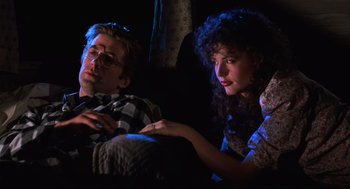 Movie still from “Beetlejuice” (1988), directed by Tim Burton – A man and a woman sitting next to each other on a couch; Medium shot, Low angle