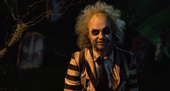 Movie still from “Beetlejuice” (1988), directed by Tim Burton – A man dressed up as beetlejuice for halloween; Medium shot, Over the shoulder angle