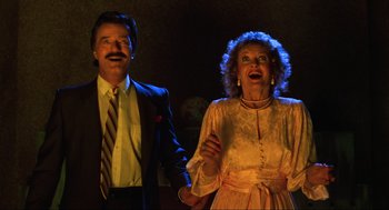 Movie still from “Beetlejuice” (1988), directed by Tim Burton – An older woman and a younger man are standing together; Medium shot, Low angle