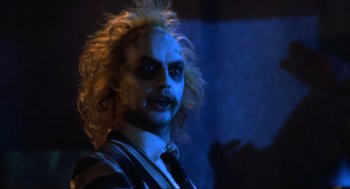 Movie still from “Beetlejuice” (1988), directed by Tim Burton – A person wearing a suit and tie; Close Up shot, Over the shoulder angle