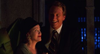 Movie still from “Beetlejuice” (1988), directed by Tim Burton – A man and a woman posing for a picture; Close Up shot, Low angle