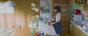Movie still from “Belle” (2021), directed by Mamoru Hosoda – A woman is standing in a kitchen pouring a cup of tea; Wide shot, High angle