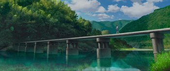Movie still from “Belle” (2021), directed by Mamoru Hosoda – A person walking across a bridge over a body of water; Extreme Wide shot, High angle