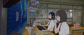 Movie still from “Belle” (2021), directed by Mamoru Hosoda – Two women sitting at a table with a computer; Wide shot, Low angle