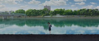 Movie still from “Belle” (2021), directed by Mamoru Hosoda – A woman standing in front of a body of water looking at her cell phone; Extreme Wide shot, High angle
