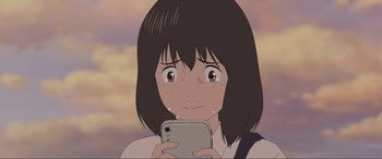 Movie still from “Belle” (2021), directed by Mamoru Hosoda – A girl is holding a cell phone in her hands; Close Up shot, Over the shoulder angle