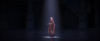 Movie still from “Belle” (2021), directed by Mamoru Hosoda – A woman standing in the middle of a dark room; Wide shot, Low angle