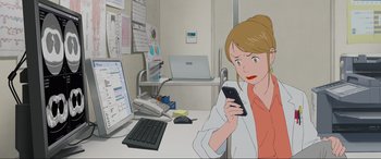 Movie still from “Belle” (2021), directed by Mamoru Hosoda – A woman sitting in front of a computer holding a cell phone; Medium shot, Low angle