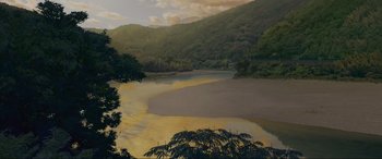 Movie still from “Belle” (2021), directed by Mamoru Hosoda – A painting of a body of water near a forest; Extreme Wide shot, High angle