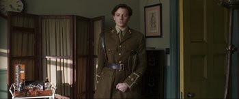 A man in a uniform standing in front of a mirror
