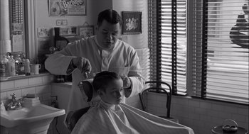 Movie still from “The Man Who Wasn't There” (2001), directed by Joel Coen – A man cutting a young boy's hair in a barber shop; Medium shot, Over the shoulder angle