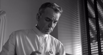 Movie still from “The Man Who Wasn't There” (2001), directed by Joel Coen – Black and white photograph of a man looking down; Close Up shot, Low angle