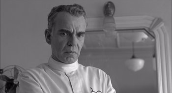 Movie still from “The Man Who Wasn't There” (2001), directed by Joel Coen – An older man wearing a white shirt and a white tie; Close Up shot, Low angle