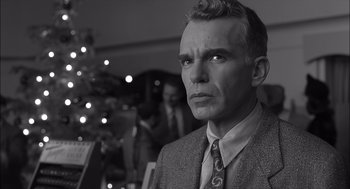 Movie still from “The Man Who Wasn't There” (2001), directed by Joel Coen – A black and white photo of a man in a suit and tie; Close Up shot, Low angle