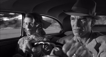 Movie still from “The Man Who Wasn't There” (2001), directed by Joel Coen – An older man and woman in the back seat of a car; Close Up shot, Low angle