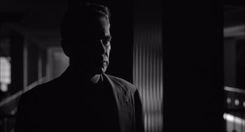 Movie still from “The Man Who Wasn't There” (2001), directed by Joel Coen – A black and white photo of a man in a suit; Close Up shot, Low angle