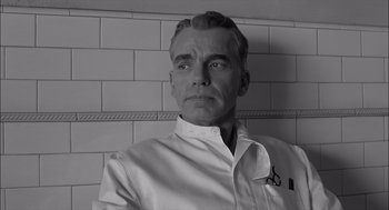 Movie still from “The Man Who Wasn't There” (2001), directed by Joel Coen – Black and white photograph of a man wearing a white shirt; Close Up shot, Low angle