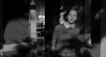 Movie still from “The Man Who Wasn't There” (2001), directed by Joel Coen – A woman in a white shirt and plaid skirt; Medium shot, Low angle