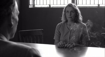 Movie still from “The Man Who Wasn't There” (2001), directed by Joel Coen – A woman sitting at a table in front of a window; Medium shot, Over the shoulder angle