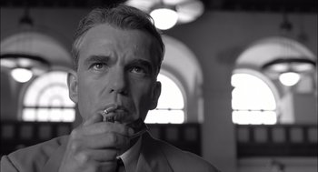 Movie still from “The Man Who Wasn't There” (2001), directed by Joel Coen – A black - and - white photo of a man holding a spoon; Close Up shot, Low angle