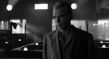 Movie still from “The Man Who Wasn't There” (2001), directed by Joel Coen – Black and white photograph of a man in a suit; Close Up shot, Low angle