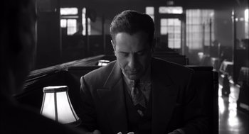 Movie still from “The Man Who Wasn't There” (2001), directed by Joel Coen – A black and white photo of a man in a suit and tie; Medium shot, Low angle