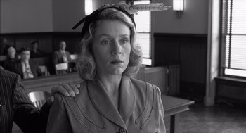 Movie still from “The Man Who Wasn't There” (2001), directed by Joel Coen – A woman in a dress with a feather in her hair; Close Up shot, Low angle