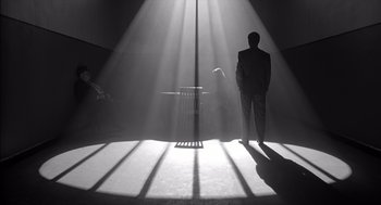 A man in a suit standing in the middle of a room