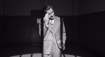 Movie still from “The Man Who Wasn't There” (2001), directed by Joel Coen – A black and white photo of a man in a suit and tie; Medium shot, High angle