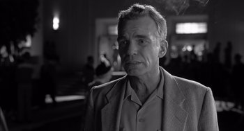 Movie still from “The Man Who Wasn't There” (2001), directed by Joel Coen – Black and white photograph of a man in a suit; Close Up shot, Low angle