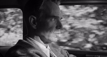 Movie still from “The Man Who Wasn't There” (2001), directed by Joel Coen – Black and white photograph of a man looking out a window; Close Up shot, Low angle