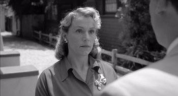 Movie still from “The Man Who Wasn't There” (2001), directed by Joel Coen – An older woman wearing a dress shirt and a bow tie; Close Up shot, Over the shoulder angle