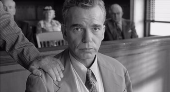 Movie still from “The Man Who Wasn't There” (2001), directed by Joel Coen – Black and white photograph of a man in a suit and tie; Close Up shot, Low angle