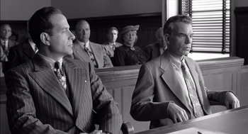 Movie still from “The Man Who Wasn't There” (2001), directed by Joel Coen – A black - and - white photo of men in a courtroom; Medium shot, Low angle