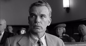 Movie still from “The Man Who Wasn't There” (2001), directed by Joel Coen – Black and white photograph of a man in a suit and tie; Close Up shot, Low angle