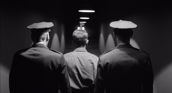 Movie still from “The Man Who Wasn't There” (2001), directed by Joel Coen – A group of men standing next to each other in a hallway; Medium shot, Low angle