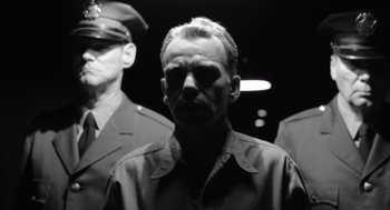 Movie still from “The Man Who Wasn't There” (2001), directed by Joel Coen – A black - and - white photo of a man in a military uniform; Close Up shot, Low angle