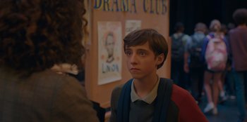 Movie still from “Better Nate Than Ever” (2022), directed by Tim Federle – A young boy is looking at a woman; Close Up shot, Over the shoulder angle