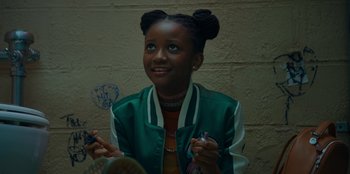 Movie still from “Better Nate Than Ever” (2022), directed by Tim Federle – A young girl is smiling while holding a cell phone; Close Up shot, Overhead angle