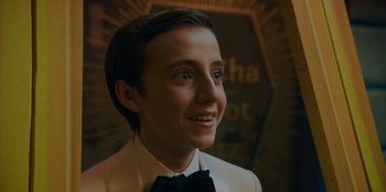 Movie still from “Better Nate Than Ever” (2022), directed by Tim Federle – A young man wearing a white suit and bow tie; Close Up shot, Low angle