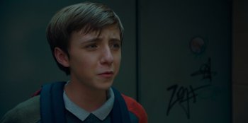 Movie still from “Better Nate Than Ever” (2022), directed by Tim Federle – A young man with short blonde hair looking to his left; Close Up shot, Over the shoulder angle
