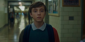 Movie still from “Better Nate Than Ever” (2022), directed by Tim Federle – A young boy standing in the hallway of a school; Close Up shot, Low angle