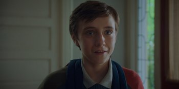 Movie still from “Better Nate Than Ever” (2022), directed by Tim Federle – A young boy with a scarf around his neck; Close Up shot, Over the shoulder angle